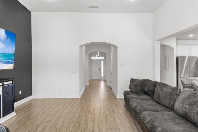 living room featuring light hardwood / wood-style floors and a towering ceiling