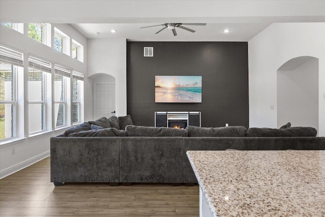 living room featuring ceiling fan and dark wood-type flooring