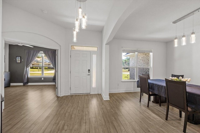 entryway featuring a notable chandelier, a healthy amount of sunlight, and wood-type flooring