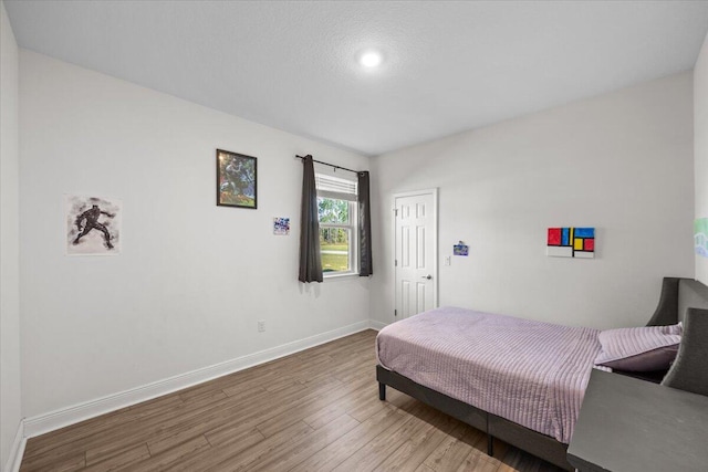 bedroom with a textured ceiling and hardwood / wood-style flooring