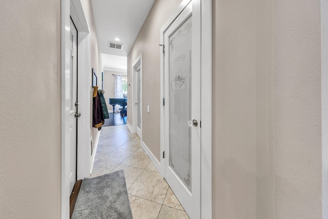 corridor with light tile patterned flooring