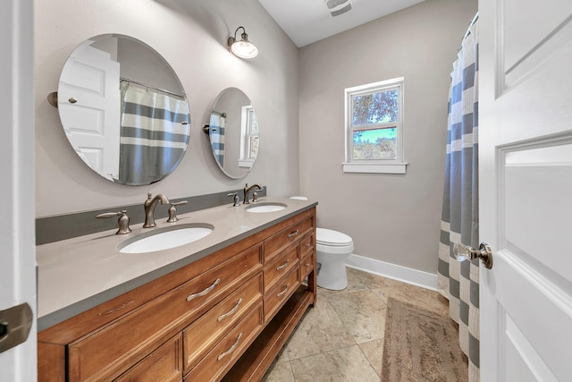 bathroom featuring tile patterned flooring, vanity, and toilet