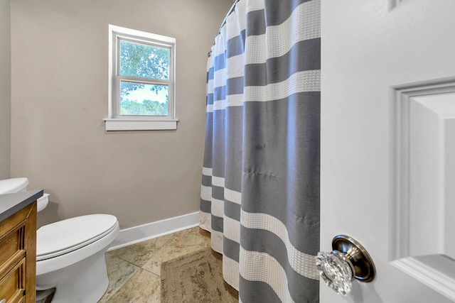 bathroom with tile patterned flooring, vanity, toilet, and walk in shower