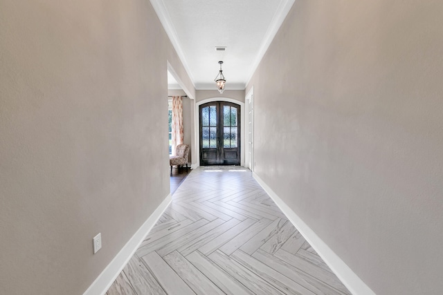 interior space featuring crown molding, french doors, and light parquet floors