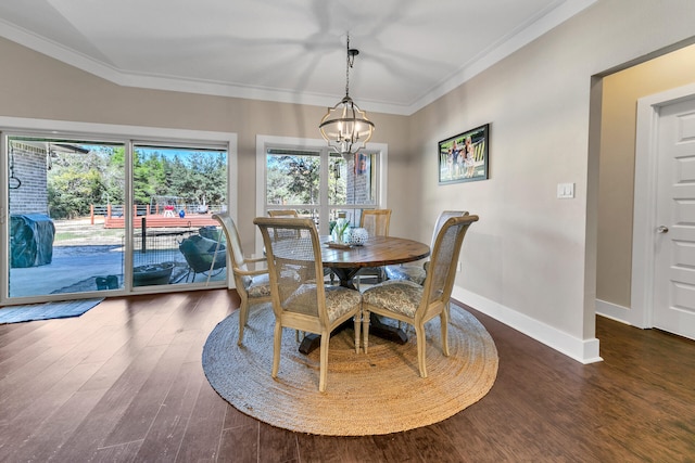 dining room with ornamental molding, dark hardwood / wood-style floors, and a notable chandelier