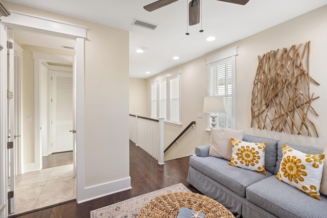 living room with dark wood-type flooring and ceiling fan