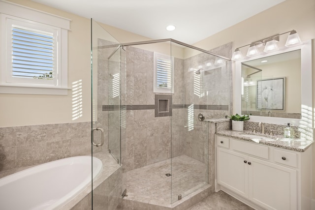 bathroom with vanity and shower with separate bathtub