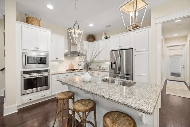 kitchen with decorative light fixtures, white cabinets, appliances with stainless steel finishes, and tasteful backsplash