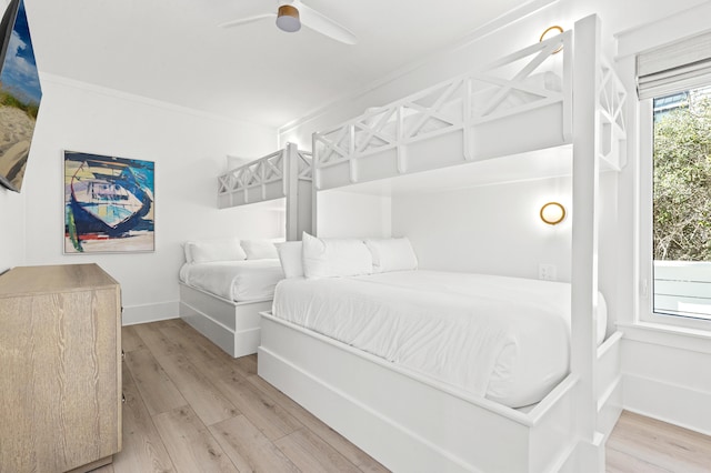 bedroom featuring light wood-type flooring, ceiling fan, and crown molding