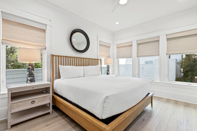 bedroom with light hardwood / wood-style flooring, ceiling fan, and crown molding