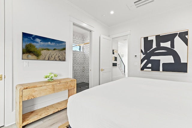 bedroom with crown molding and hardwood / wood-style floors