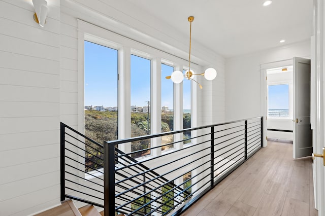 corridor featuring light hardwood / wood-style floors and an inviting chandelier