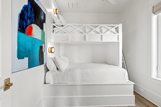 bedroom with wood-type flooring and ornamental molding