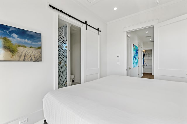 bedroom featuring a barn door and ensuite bath