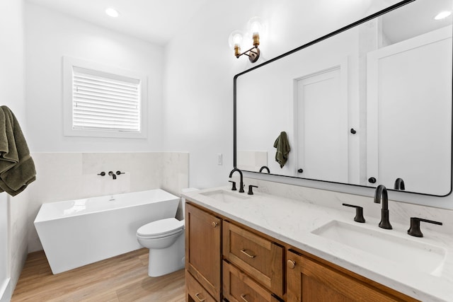 bathroom featuring a bathing tub, vanity, toilet, and hardwood / wood-style floors