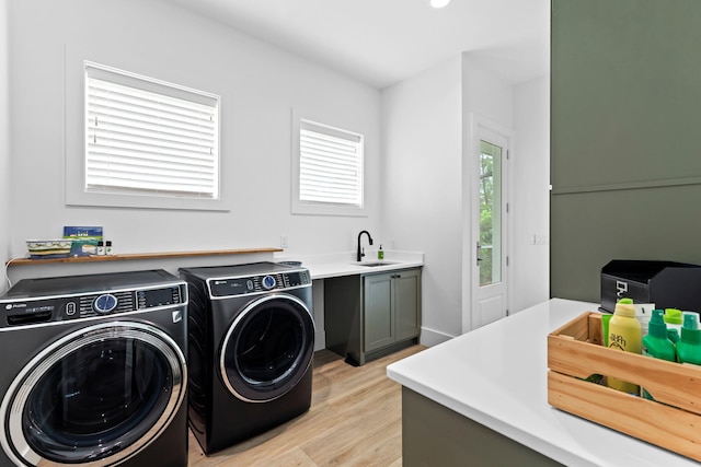 laundry room featuring sink, washer and dryer, and light wood-type flooring