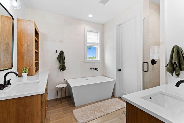 bathroom with hardwood / wood-style flooring, vanity, and independent shower and bath