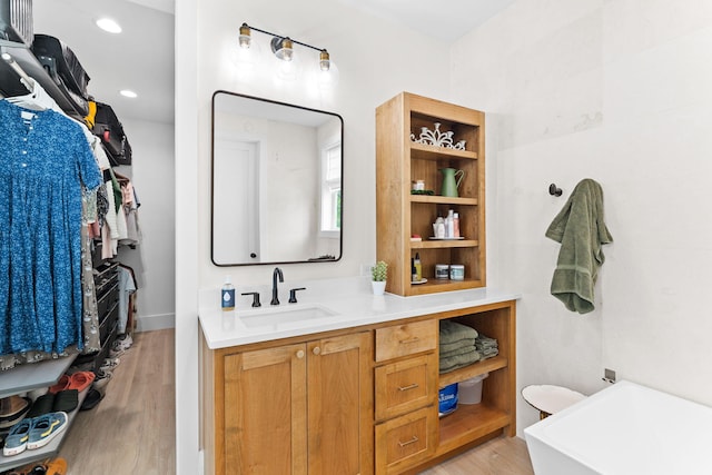 bathroom featuring vanity, wood-type flooring, and a washtub