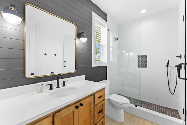 bathroom featuring hardwood / wood-style floors, vanity, toilet, and a shower with shower door