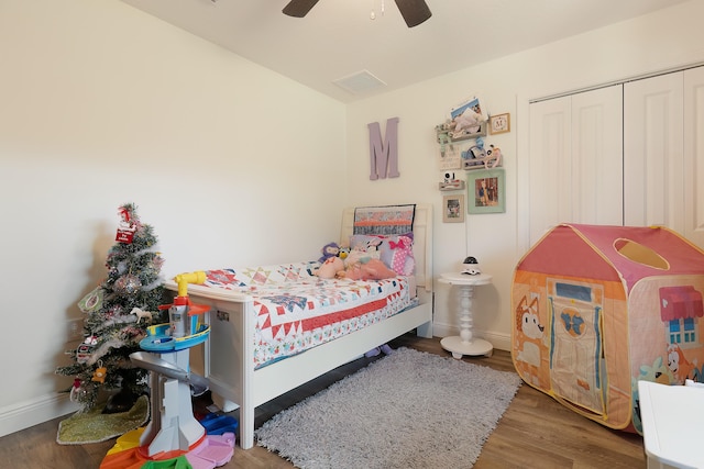 bedroom with hardwood / wood-style flooring, ceiling fan, and a closet