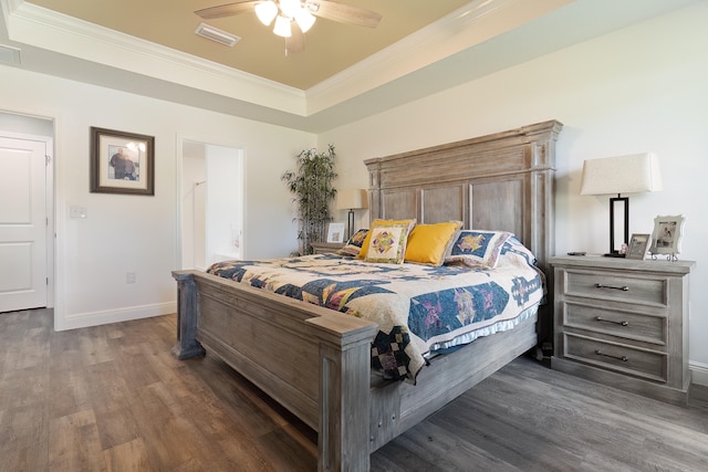 bedroom featuring a tray ceiling, crown molding, ceiling fan, and dark wood-type flooring