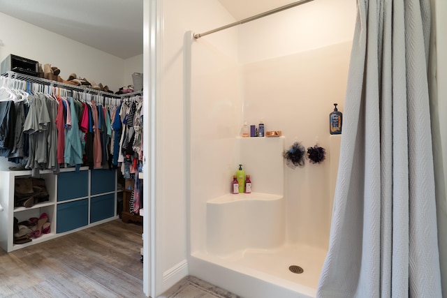 bathroom with a shower with shower curtain and wood-type flooring