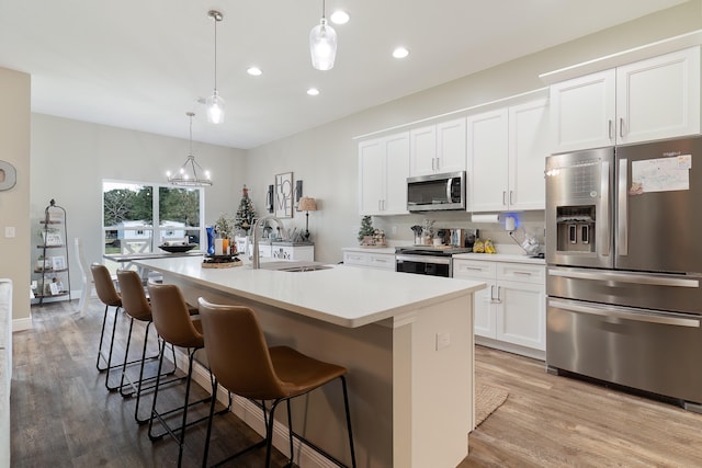 kitchen featuring white cabinetry, a kitchen island with sink, sink, and stainless steel appliances