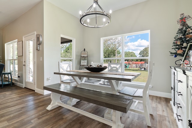 dining area with plenty of natural light, hardwood / wood-style floors, and a notable chandelier