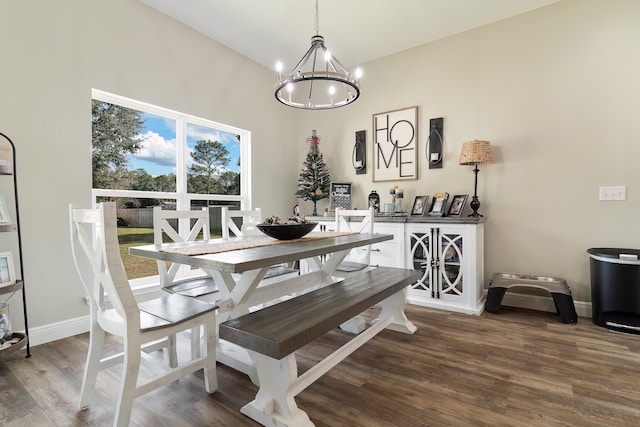 dining space with hardwood / wood-style floors and an inviting chandelier