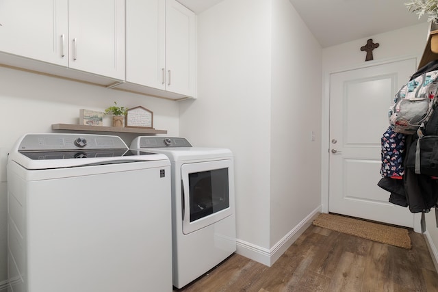 laundry area featuring cabinets, dark hardwood / wood-style floors, and washer and clothes dryer