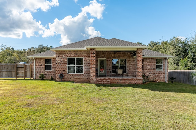 back of property with a yard and a patio