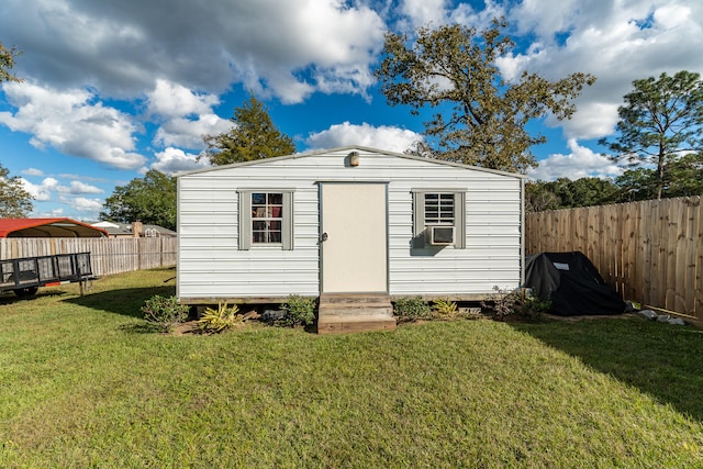 view of outbuilding featuring cooling unit and a lawn