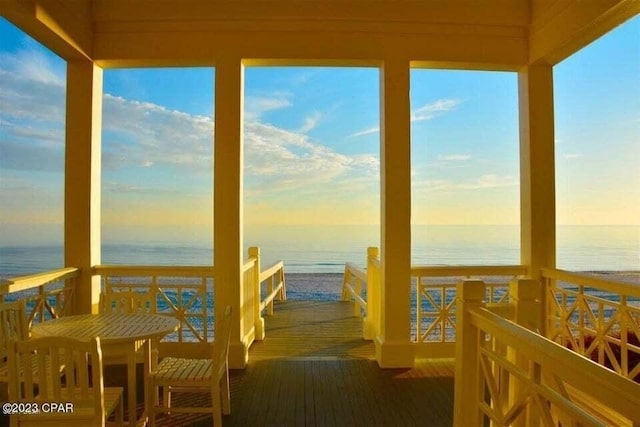 dock area with a water view and a beach view