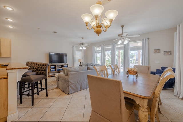 tiled dining room with ceiling fan with notable chandelier