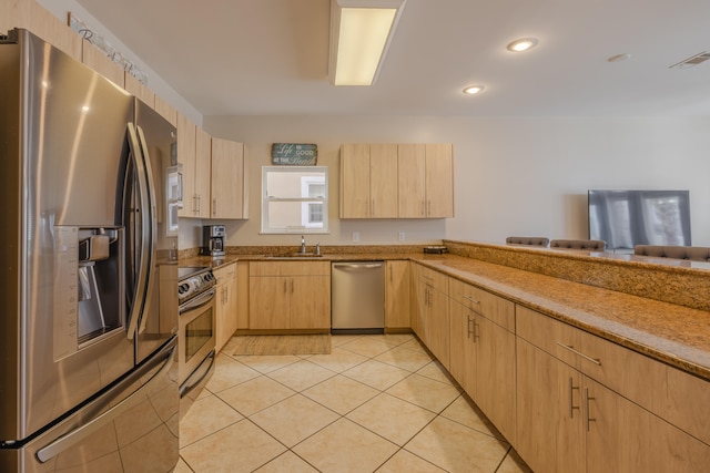 kitchen featuring light brown cabinets, sink, light tile patterned flooring, kitchen peninsula, and stainless steel appliances