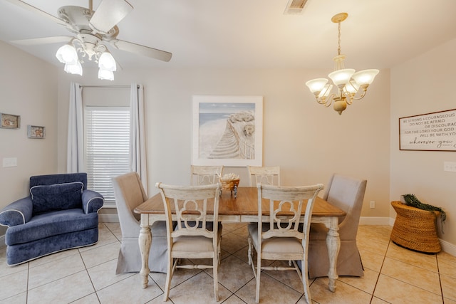 tiled dining space with ceiling fan with notable chandelier