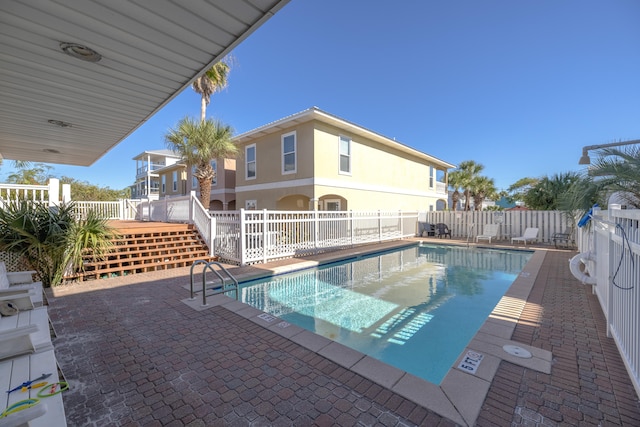 view of swimming pool featuring a patio and a wooden deck