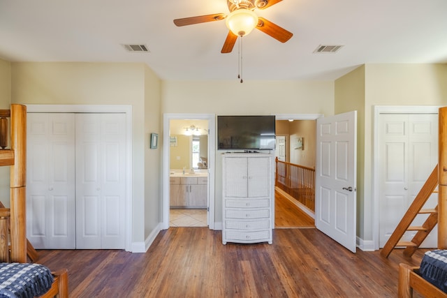 bedroom featuring ensuite bath, ceiling fan, and dark wood-type flooring