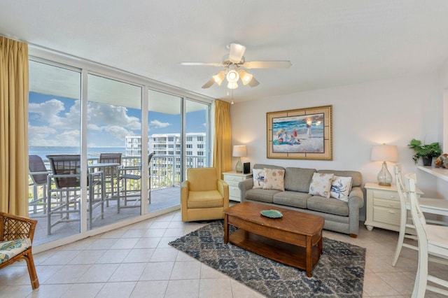 tiled living room with a wall of windows, a water view, and ceiling fan