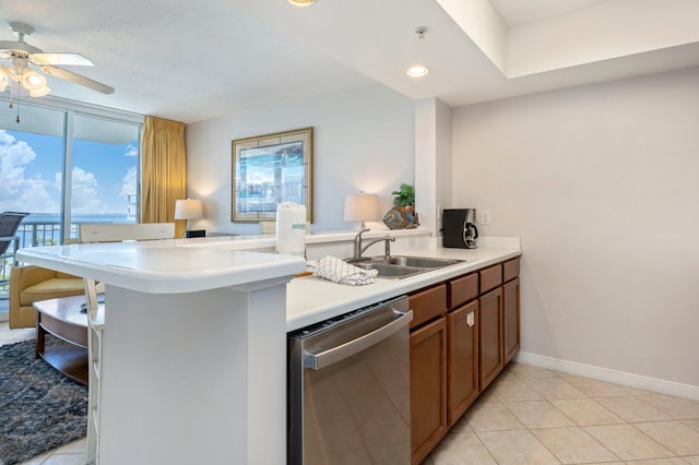 kitchen featuring kitchen peninsula, ceiling fan, sink, light tile patterned floors, and dishwasher