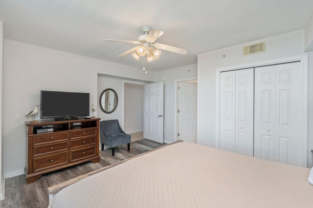 bedroom with ceiling fan, a closet, and dark wood-type flooring