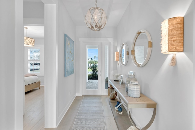 interior space featuring a chandelier, light hardwood / wood-style flooring, and a healthy amount of sunlight