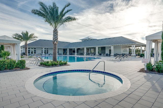 view of pool featuring a community hot tub and a patio