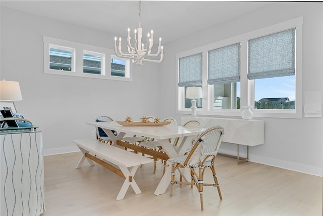 dining room with light hardwood / wood-style floors and a notable chandelier