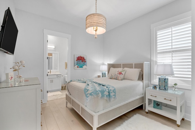 bedroom with light hardwood / wood-style floors and ensuite bath