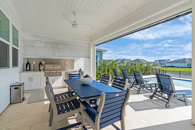 view of patio featuring an outdoor kitchen, a water view, a swimming pool, ceiling fan, and area for grilling