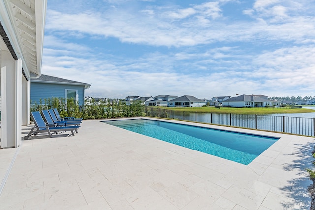 view of swimming pool with a patio area and a water view