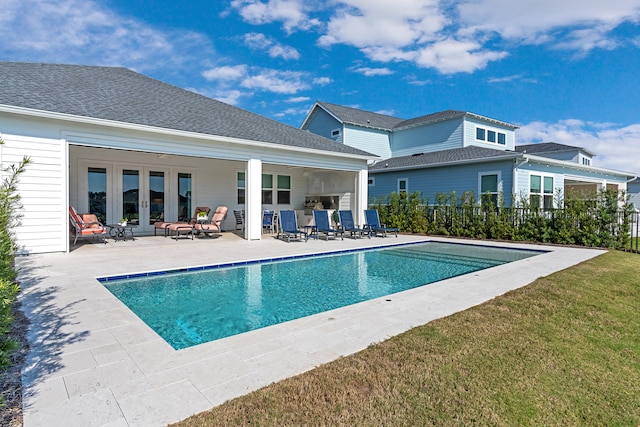 view of swimming pool with a lawn, a patio, and french doors