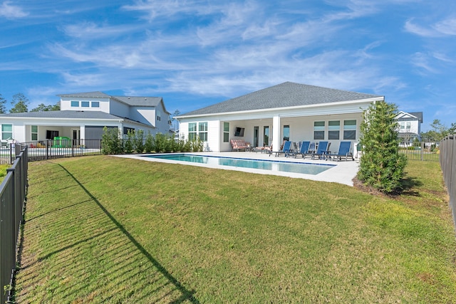 back of property featuring a fenced in pool, a yard, and a patio