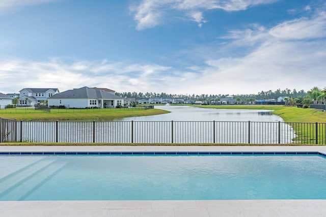 view of pool with a yard and a water view